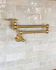 Wall-mounted solid brass pot filler faucet with articulated arm for kitchen stoves
