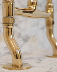 Unlacquered brass bridge kitchen faucet with graceful curved legs