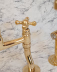 Artisanal curved-leg brass bridge faucet for kitchen sinks