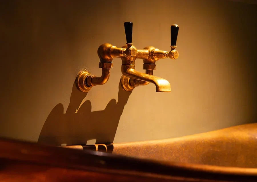 Antique brass faucet over vintage brass bath