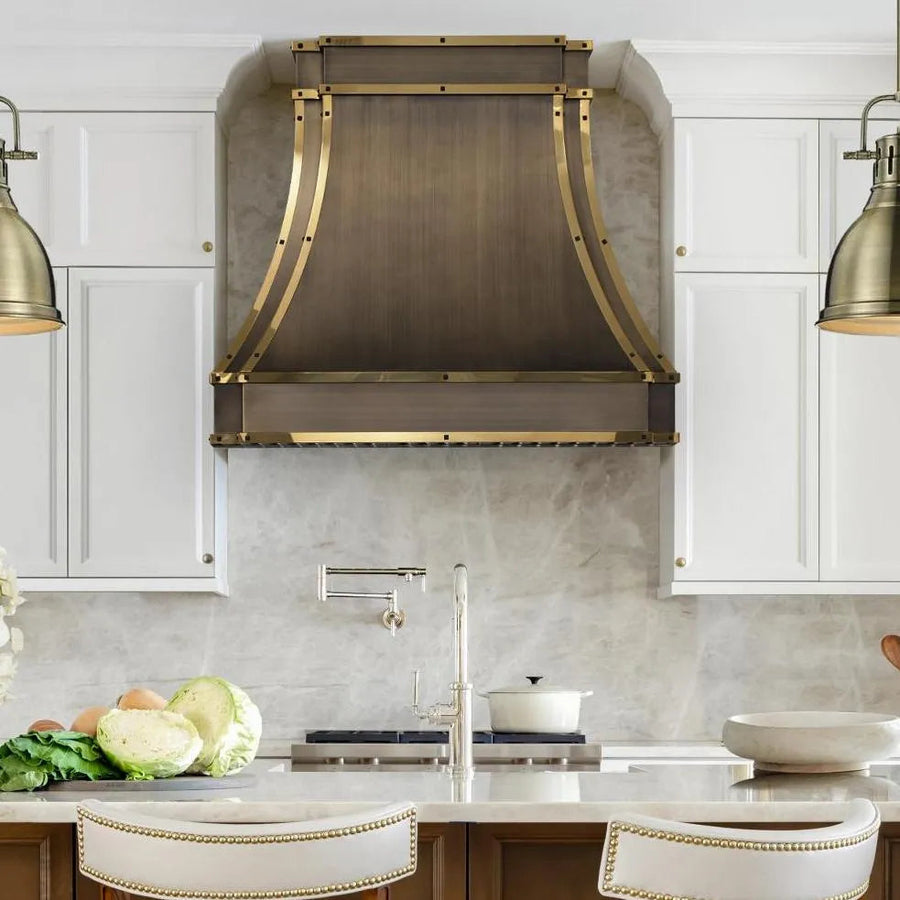 Antique brass range hood cover above a kitchen range