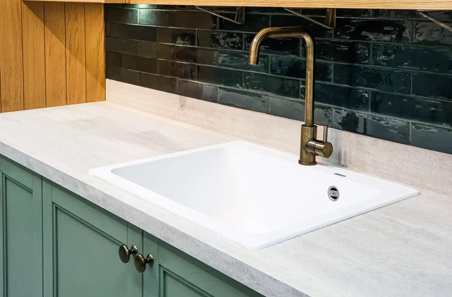A modern kitchen with subway-tile backsplash and a brass faucet.