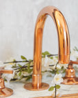 Deck mounted gooseneck bathroom faucet in copper finish