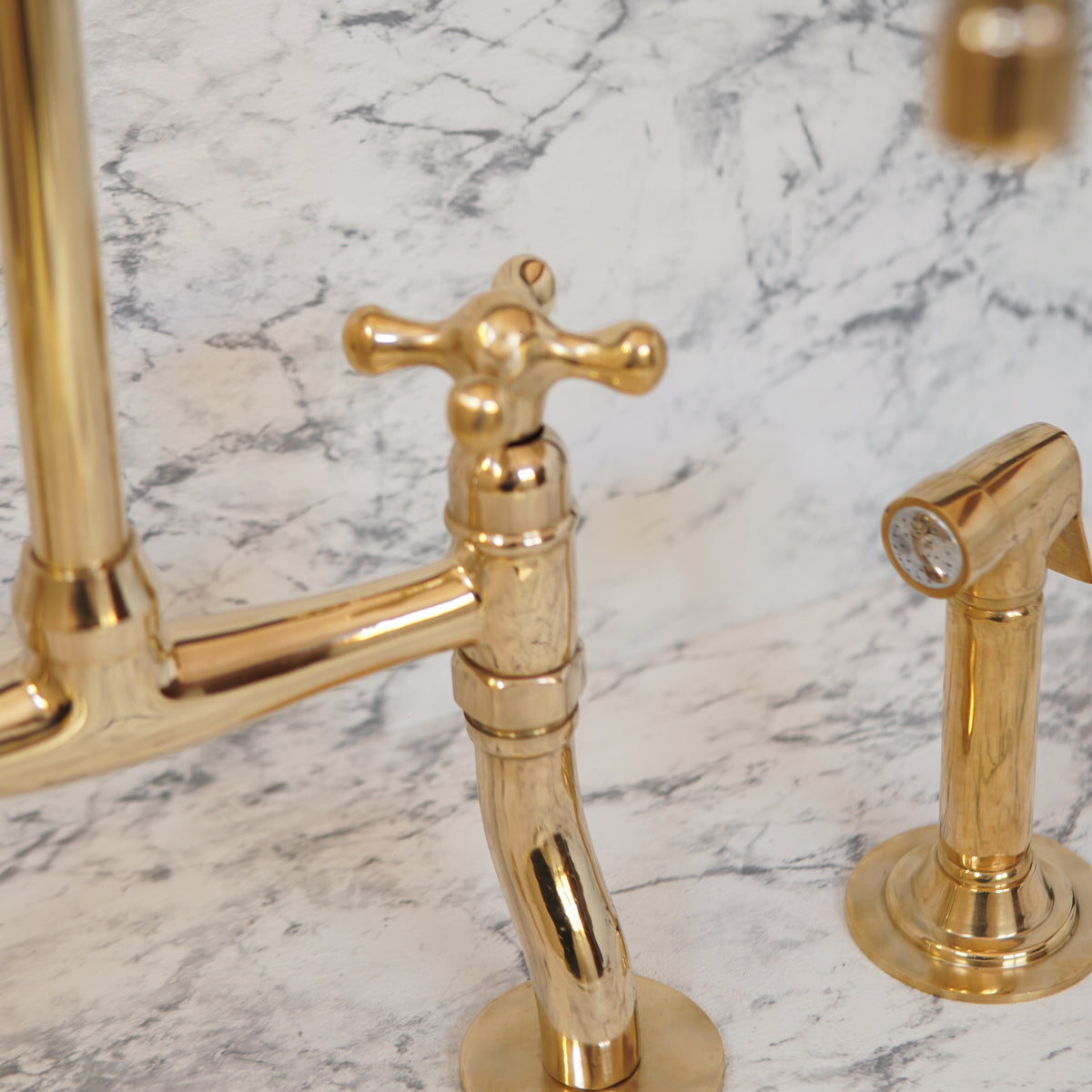 Artisanal curved-leg brass bridge faucet for kitchen sinks
