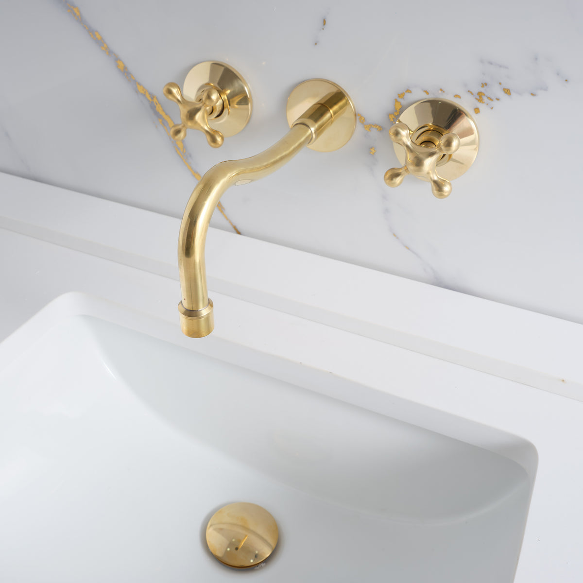 Curved wall-mounted unlacquered brass faucet crafted from solid lead-free brass