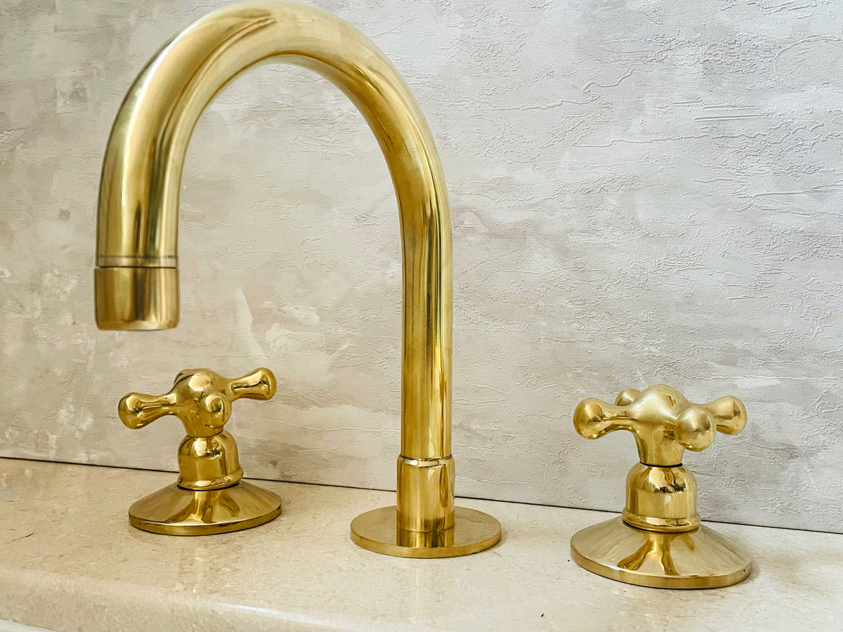 Deck-mounted brass faucet with three holes for bathroom sinks