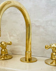 Deck-mounted brass faucet with three holes for bathroom sinks
