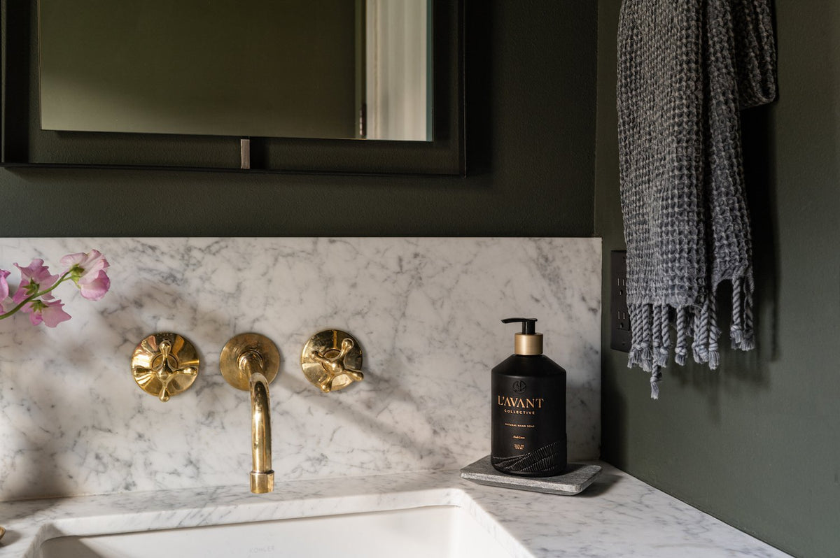 Unlacquered brass wall mount bathroom faucet that develops a natural patina